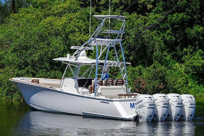 Miss Allied Yacht Photos Pics 2022 Valhalla V41 boat with four Mercury engines, docked near lush greenery.