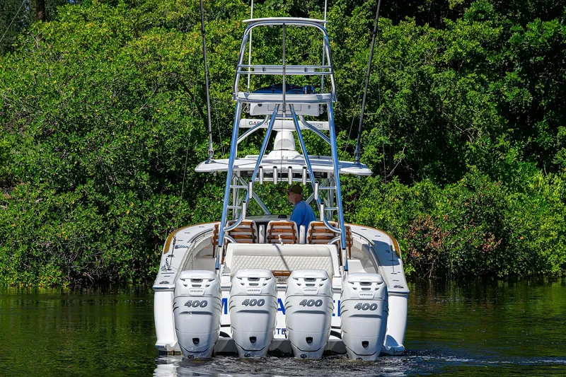 Miss Allied Yacht Photos Pics 2022 Valhalla V41 boat with four engines cruising on a river, surrounded by lush greenery.