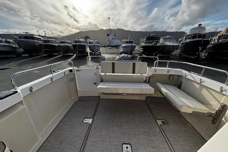  Yacht Photos Pics 2026 Ranger Tugs R-23 boat interior with seating, docked among other boats.