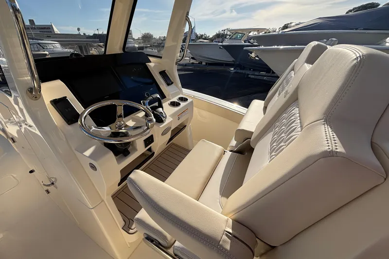  Yacht Photos Pics 2026 Scout 260 LXF boat interior with steering wheel and plush seating.