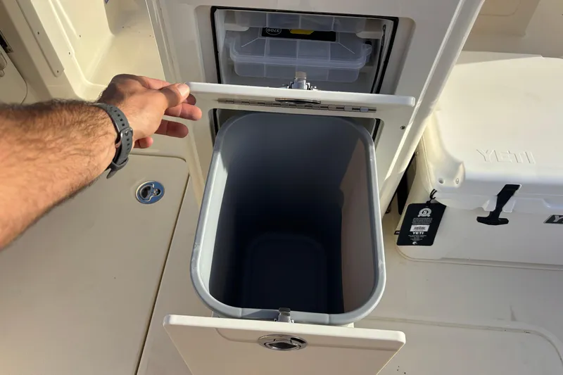  Yacht Photos Pics Hand opening storage compartment on 2026 Scout 260 LXF boat, with cooler and bin.