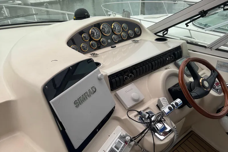 Lubb Shack Yacht Photos Pics Helm of 2000 Cruisers Yachts 3870 Express with Simrad navigation system and wooden steering wheel.