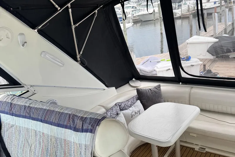 Lubb Shack Yacht Photos Pics Interior of 2000 Cruisers Yachts 3870 Express with cozy seating and table, dockside view.