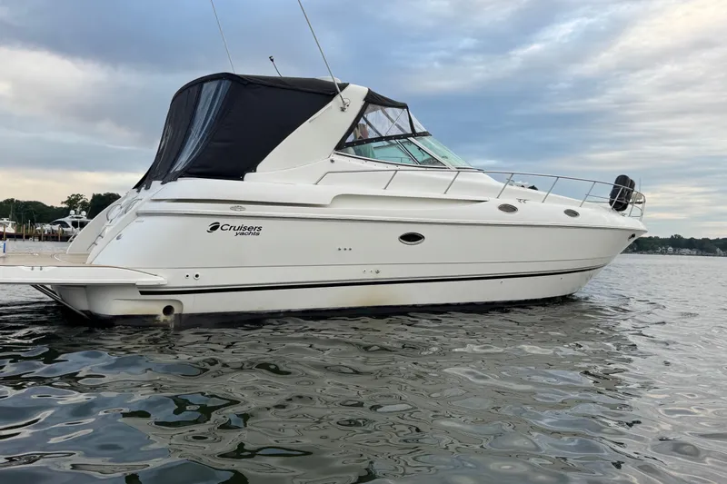 Lubb Shack Yacht Photos Pics 2000 Cruisers Yachts 3870 Express on calm water under cloudy sky.