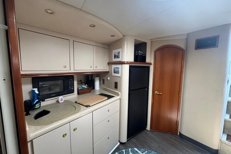 Lubb Shack Yacht Photos Pics Interior of 2000 Cruisers Yachts 3870 Express, featuring a compact kitchen with cabinets and appliances.