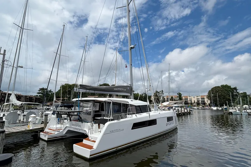 Godspeed Yacht Photos Pics 2023 Nautitech 44 Open catamaran docked at marina under blue sky.