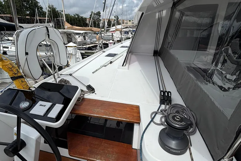 Godspeed Yacht Photos Pics 2023 Nautitech 44 Open catamaran deck with steering wheel and winch, docked at marina.