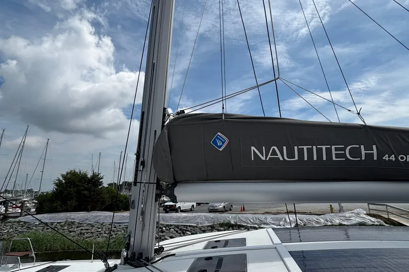 Godspeed Yacht Photos Pics 2023 Nautitech 44 Open sailboat mast and sail cover under a partly cloudy sky.