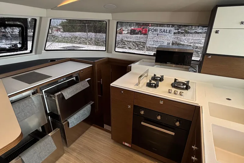 Godspeed Yacht Photos Pics Modern kitchen interior of 2023 Nautitech 44 Open catamaran with stove and oven.