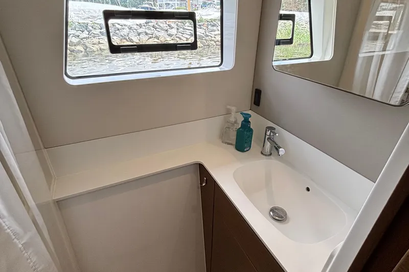 Godspeed Yacht Photos Pics Modern bathroom interior on 2023 Nautitech 44 Open yacht, featuring sleek sink and window.