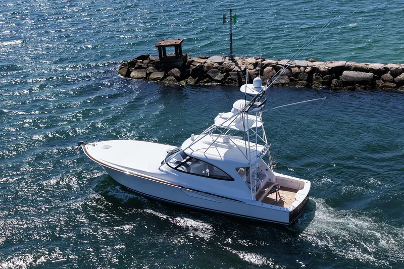 Pamela Yacht Photos Pics 2024 Viking 48 Sport Tower yacht cruising near rocky shoreline.