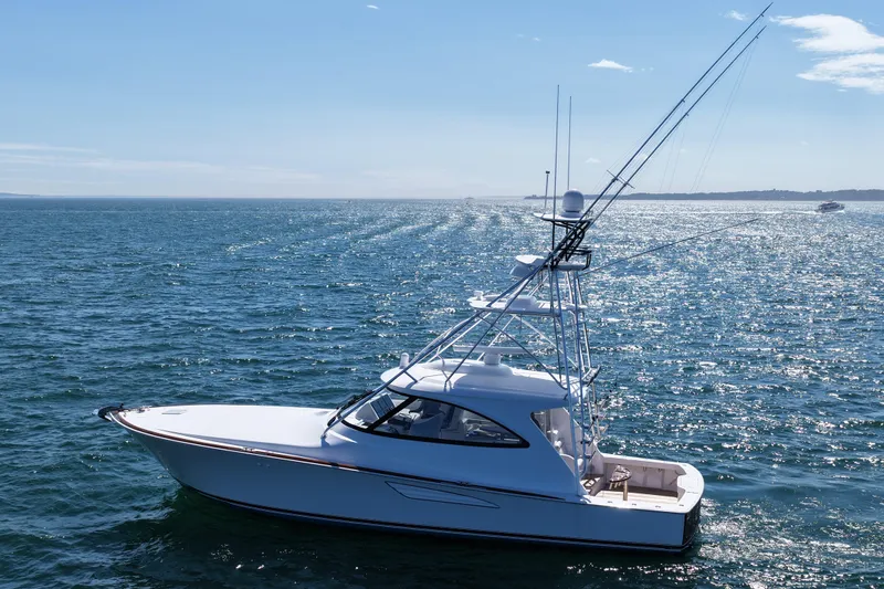 Pamela Yacht Photos Pics 2024 Viking 48 Sport Tower yacht cruising on open sea under clear blue sky.