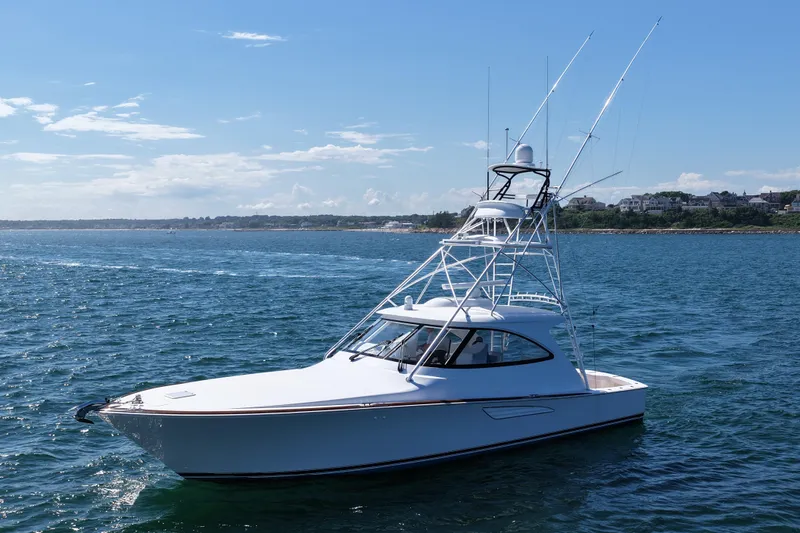 Pamela Yacht Photos Pics 2024 Viking 48 Sport Tower yacht on open water under clear blue sky.