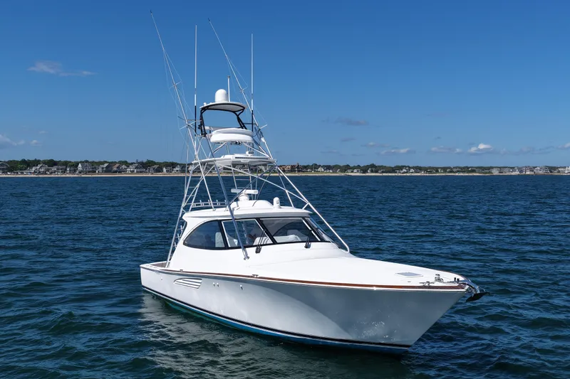 Pamela Yacht Photos Pics 2024 Viking 48 Sport Tower yacht on open water under clear blue sky.