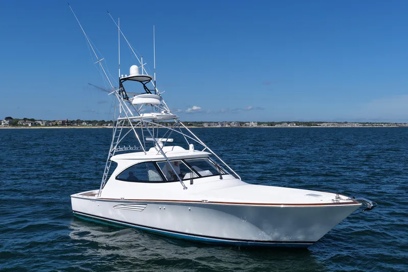 Pamela Yacht Photos Pics 2024 Viking 48 Sport Tower yacht on open water under clear blue sky.
