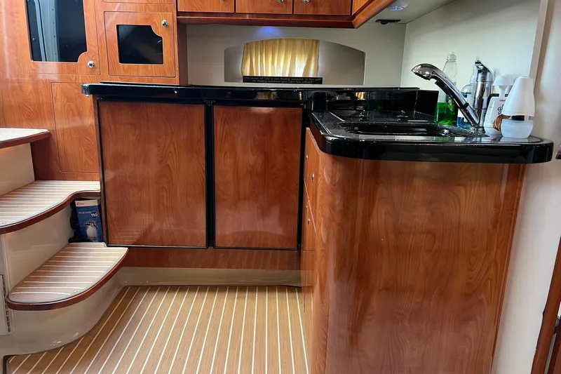  Yacht Photos Pics 2008 Four Winns 378 Vista yacht interior with wood cabinetry and compact kitchen area.