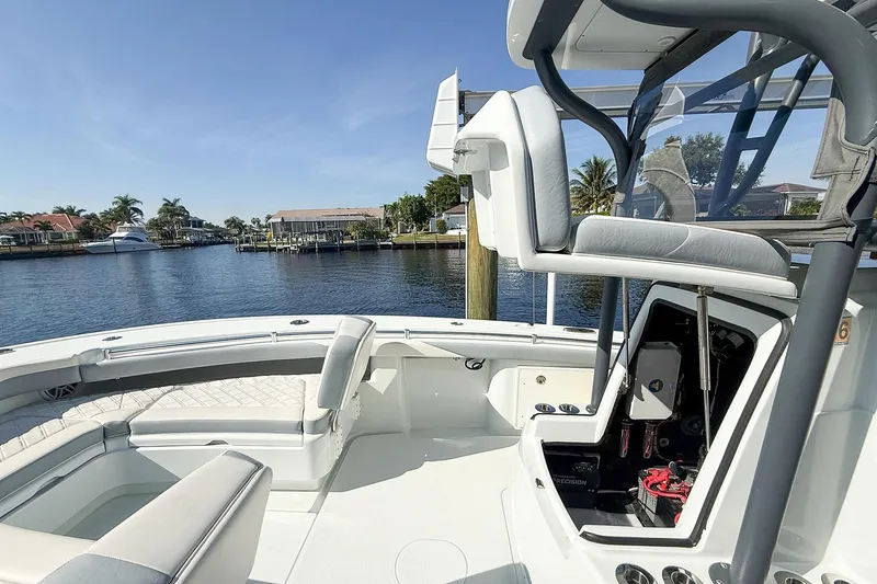  Yacht Photos Pics 2022 Yellowfin 26 Hybrid boat interior with seating and open storage, docked by waterfront homes.
