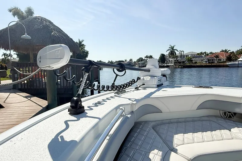  Yacht Photos Pics 2022 Yellowfin 26 Hybrid boat docked by a scenic waterfront with palm trees.