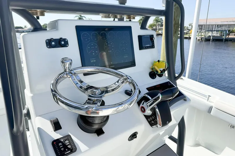  Yacht Photos Pics Control panel of 2022 Yellowfin 26 Hybrid boat with steering wheel and digital display.
