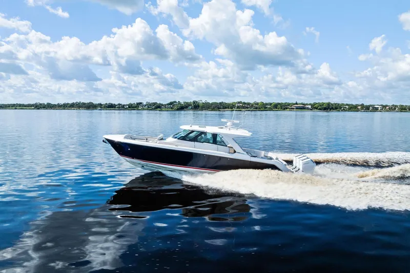 Moonrunner Yacht Photos Pics 2024 Tiara Yachts 48 LS cruising on a calm, sunny lake.