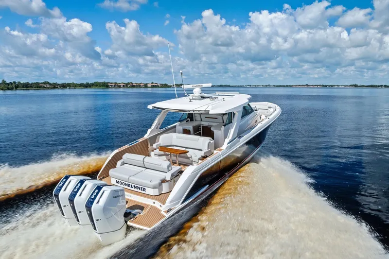Moonrunner Yacht Photos Pics 2024 Tiara Yachts 48 LS cruising on a serene lake under a blue sky.