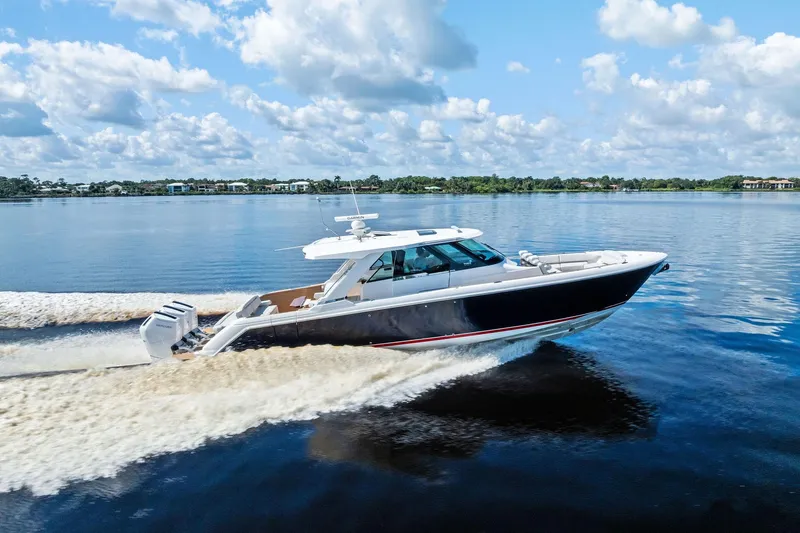 Moonrunner Yacht Photos Pics 2024 Tiara Yachts 48 LS cruising on a serene lake under a cloudy sky.