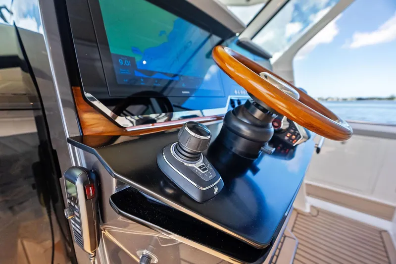 Moonrunner Yacht Photos Pics 2024 Tiara Yachts 48 LS helm with wooden steering wheel and navigation display.