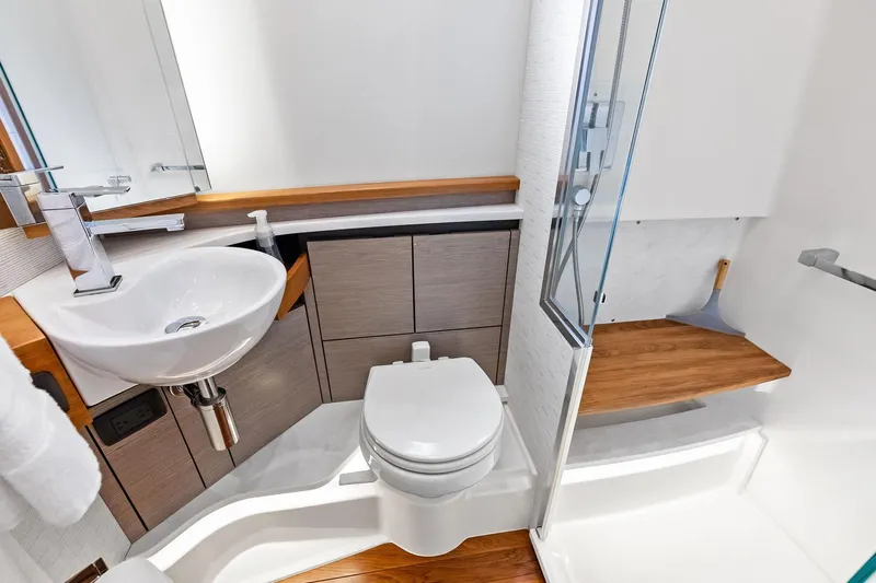 Moonrunner Yacht Photos Pics 2024 Tiara Yachts 48 LS bathroom with modern sink, toilet, and shower.