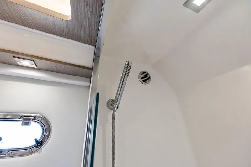 Moonrunner Yacht Photos Pics 2024 Tiara Yachts 48 LS shower area with modern fixtures and porthole window.