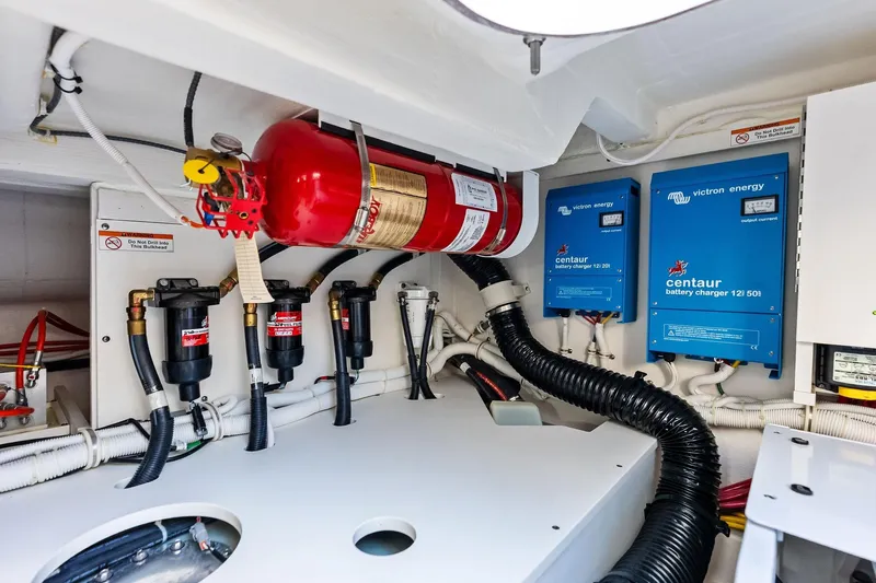 Moonrunner Yacht Photos Pics Engine room of 2024 Tiara Yachts 48 LS with fire extinguisher and battery chargers.