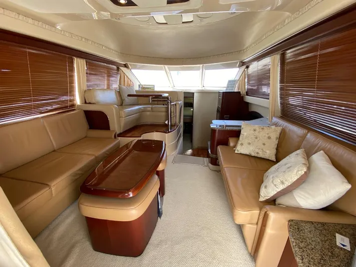  Yacht Photos Pics Luxurious interior of 2005 Sea Ray 420 Sedan Bridge with leather seating and wooden accents.