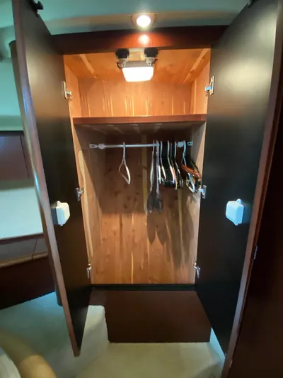  Yacht Photos Pics Open wooden closet with hangers inside a 2005 Sea Ray 420 Sedan Bridge yacht.