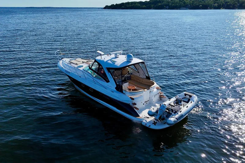 Outstanding Yacht Photos Pics 2007 Doral Alegria yacht on serene water with inflatable boat, under clear blue sky.