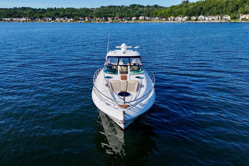 Outstanding Yacht Photos Pics 2007 Doral Alegria yacht cruising on a serene lake with distant shoreline houses.