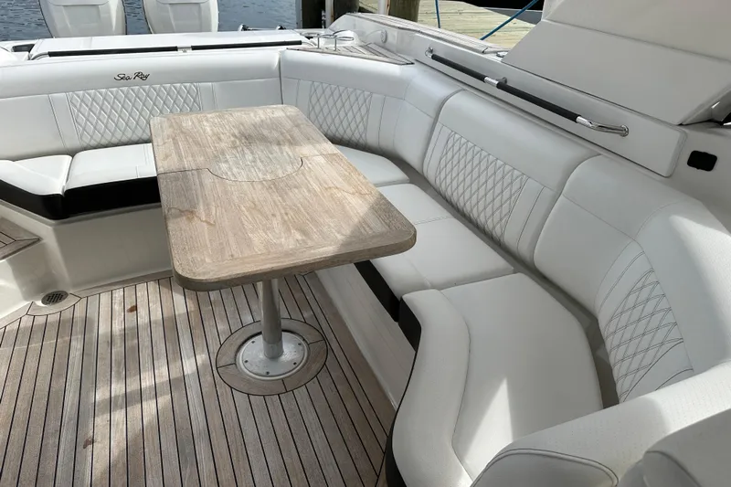 Yacht Photos Pics Luxurious seating area on 2019 Sea Ray SLX 350 Outboard with wooden table and white upholstery.