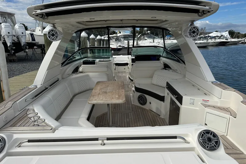  Yacht Photos Pics 2019 Sea Ray SLX 350 Outboard boat interior with seating, table, and speakers at a marina.