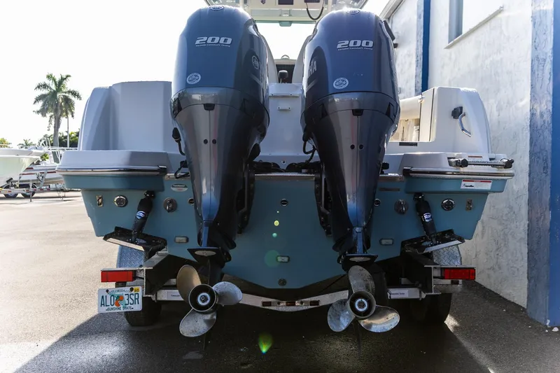  Yacht Photos Pics 2022 Sailfish 272 CC boat with dual 200 HP outboard engines, parked outdoors.