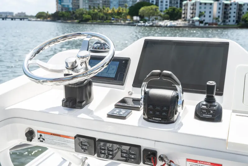 More Life Yacht Photos Pics Control panel of a 2020 Everglades 435 Center Console boat with steering wheel and navigation equipment.