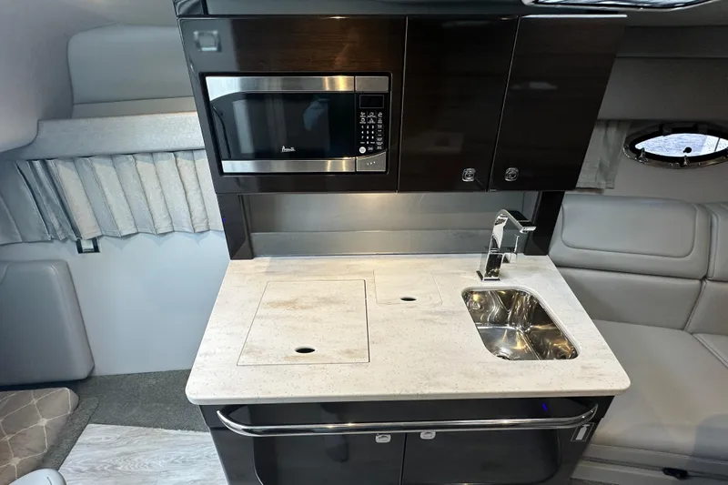  Yacht Photos Pics 2021 Formula 350 Sun Sport interior kitchen with microwave, sink, and modern cabinetry.