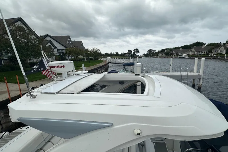  Yacht Photos Pics 2021 Formula 350 Sun Sport boat docked by waterfront homes under cloudy skies.