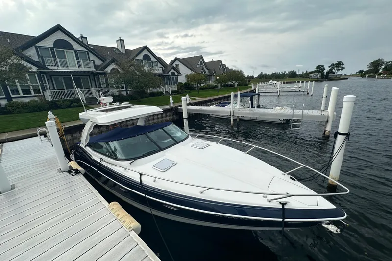  Yacht Photos Pics 2021 Formula 350 Sun Sport docked near waterfront homes under cloudy skies.
