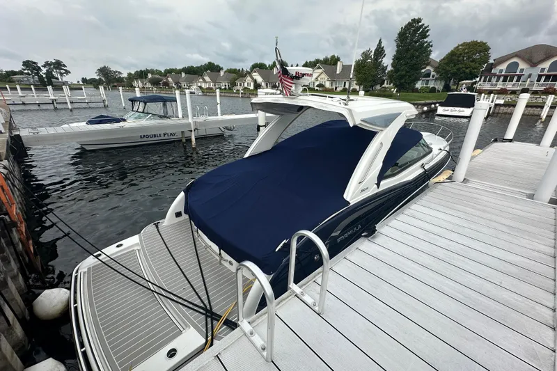  Yacht Photos Pics 2021 Formula 350 Sun Sport docked at marina with cover, surrounded by boats and waterfront homes.