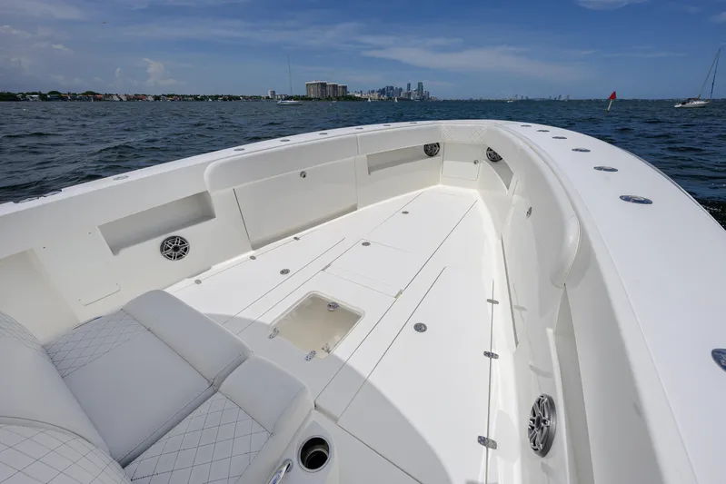 39z Yacht Photos Pics 2017 SeaVee 390 boat deck with spacious seating, ocean view, and city skyline in the background.