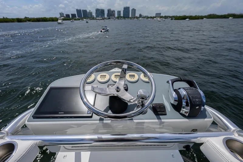 39z Yacht Photos Pics 2017 SeaVee 390 helm with steering wheel, controls, and city skyline in the background.