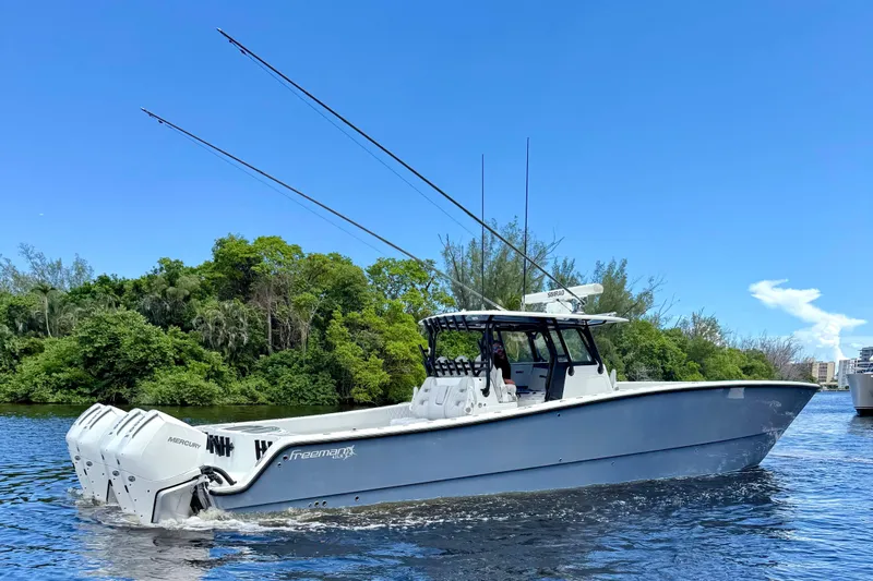  Yacht Photos Pics 2019 Freeman 42 LR boat cruising on a sunny day, surrounded by lush greenery.