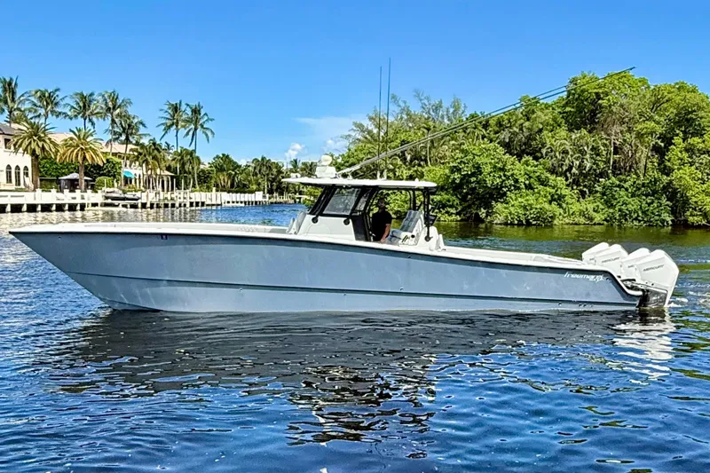  Yacht Photos Pics 2019 Freeman 42 LR boat on a sunny day, cruising near lush greenery and waterfront homes.