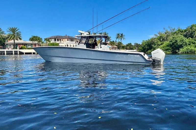  Yacht Photos Pics 2019 Freeman 42 LR boat on calm water, surrounded by lush greenery and luxury homes.