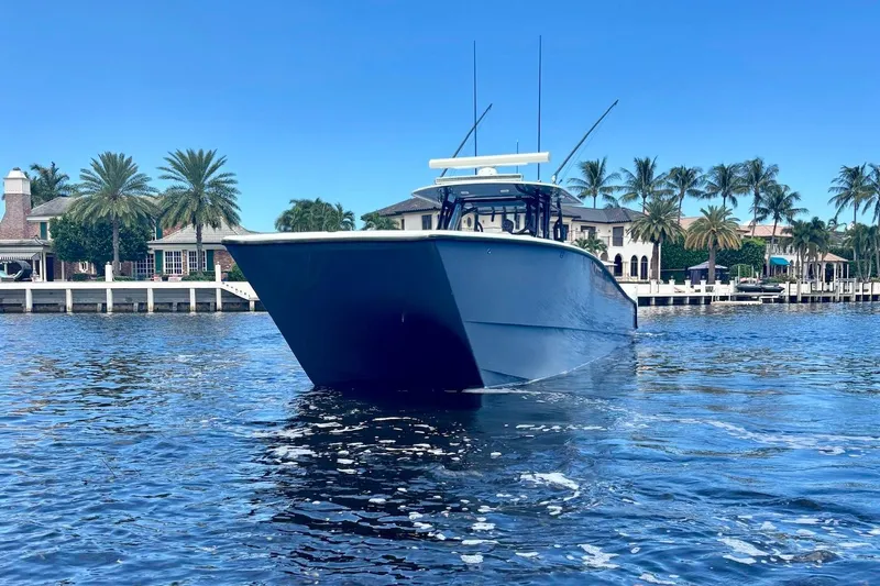  Yacht Photos Pics 2019 Freeman 42 LR boat on water, with palm trees and luxury homes in the background.