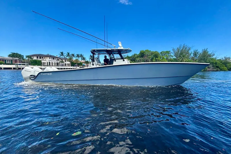  Yacht Photos Pics 2019 Freeman 42 LR boat cruising on a sunny day, surrounded by lush greenery.