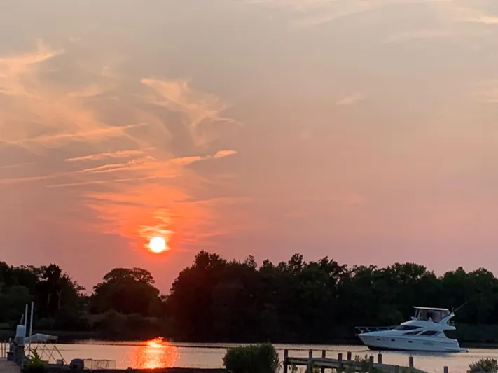  Yacht Photos Pics Sunset over a river with a 2005 Silverton 38 Sport Bridge yacht.